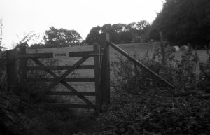 A black and white photograph taken with voigtlander vito 1 film camera of a private sign on a gate to a field